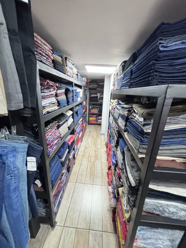 Corredor com prateleiras cheias de calças jeans